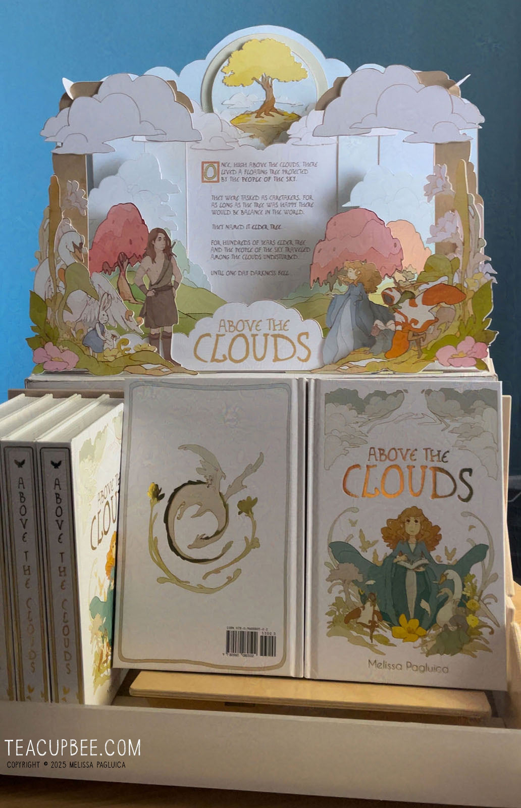 Children's book titled 'Above the Clouds' with a pop-up display on a blue background