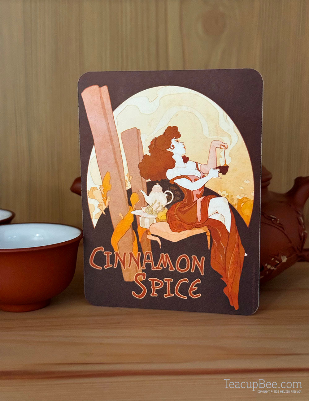 Decorative card with a woman and cinnamon sticks labeled 'Cinnamon Spice' on a wooden surface.