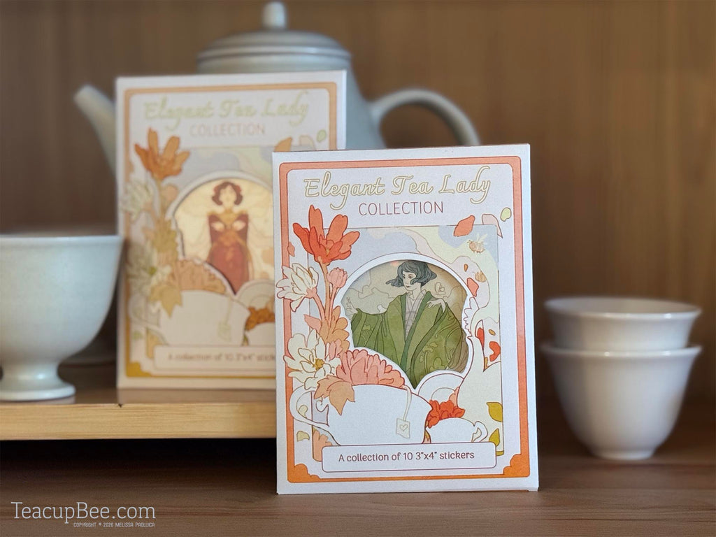 Tea packaging with decorative design and text on a wooden surface with teacups and a teapot.