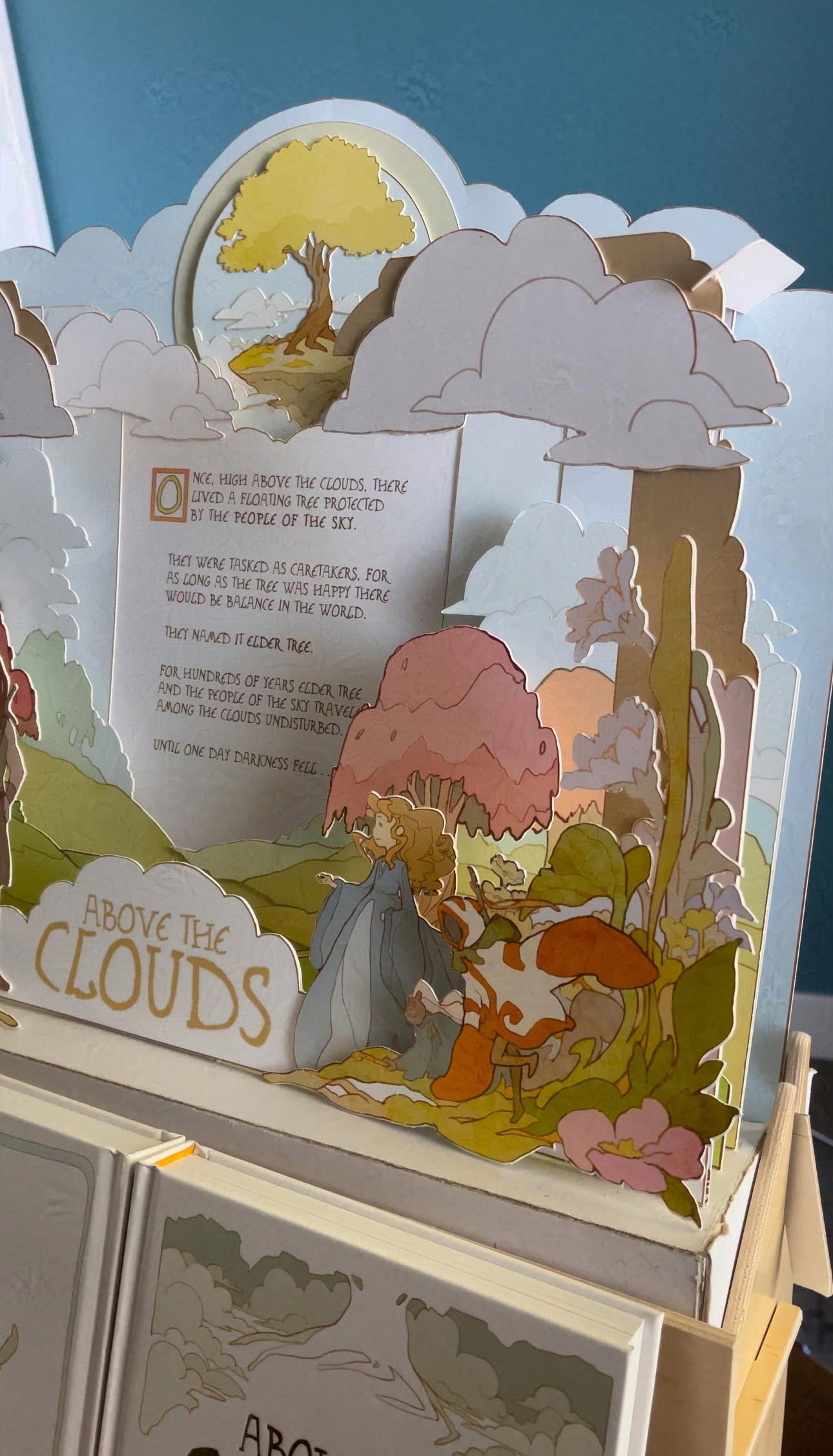 Pop-up display with a landscape scene, trees, and characters on a stand.