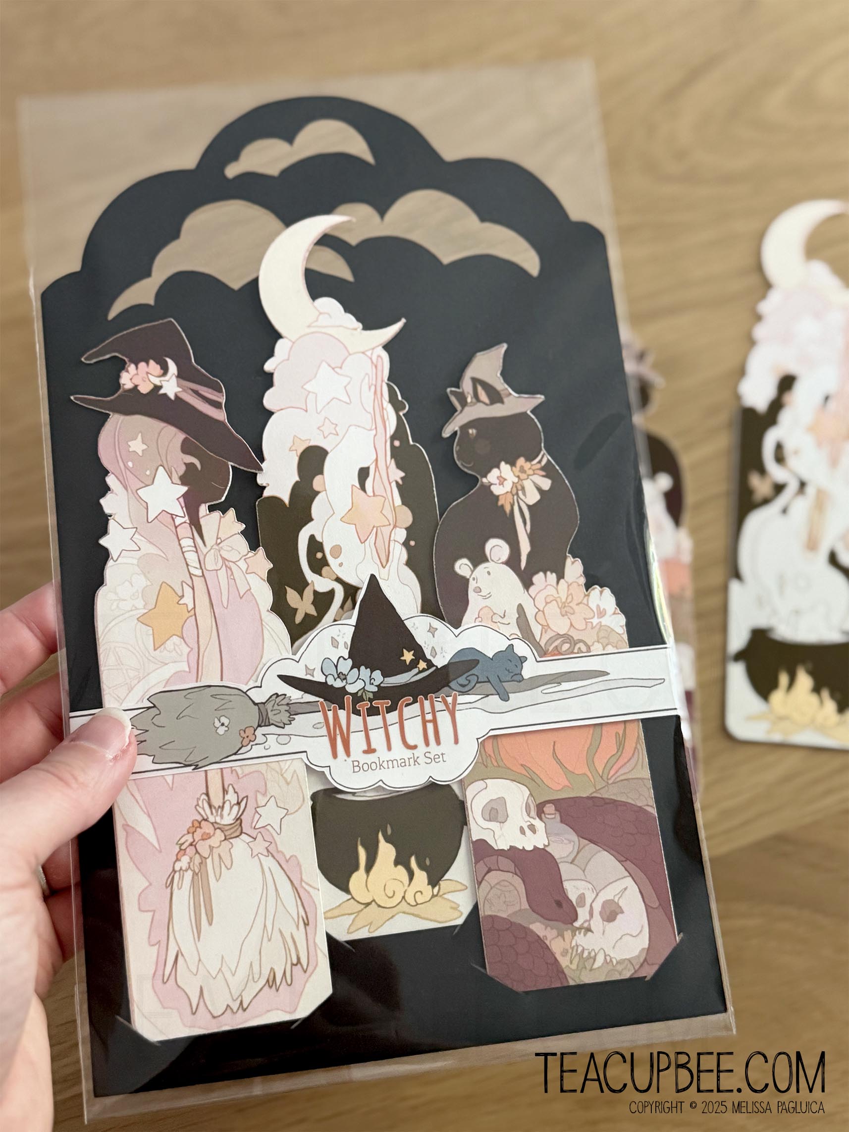 Packaged witch-themed bookmarks with a person holding the packaging.