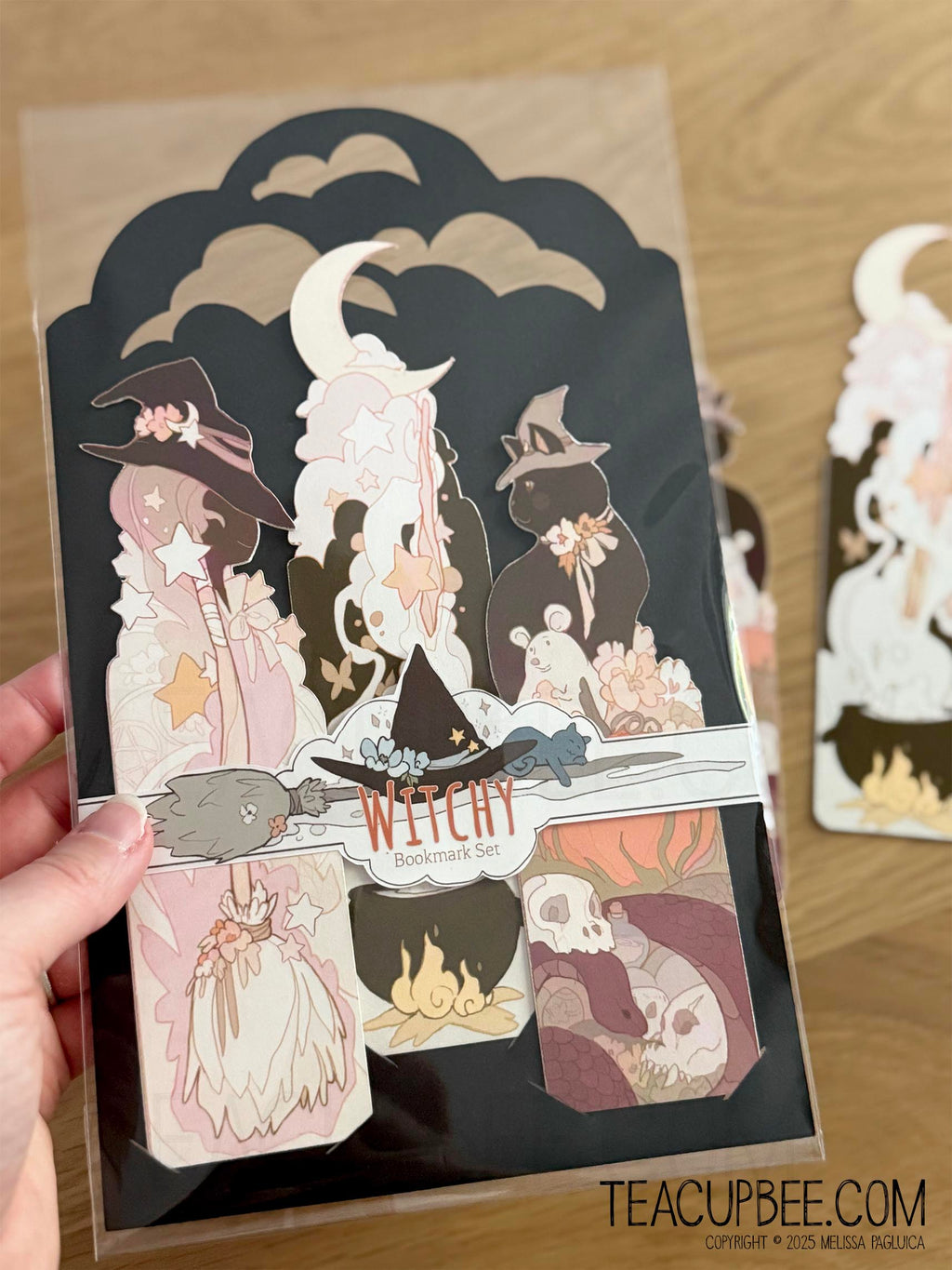 Packaged witch-themed bookmarks with a person holding the packaging.
