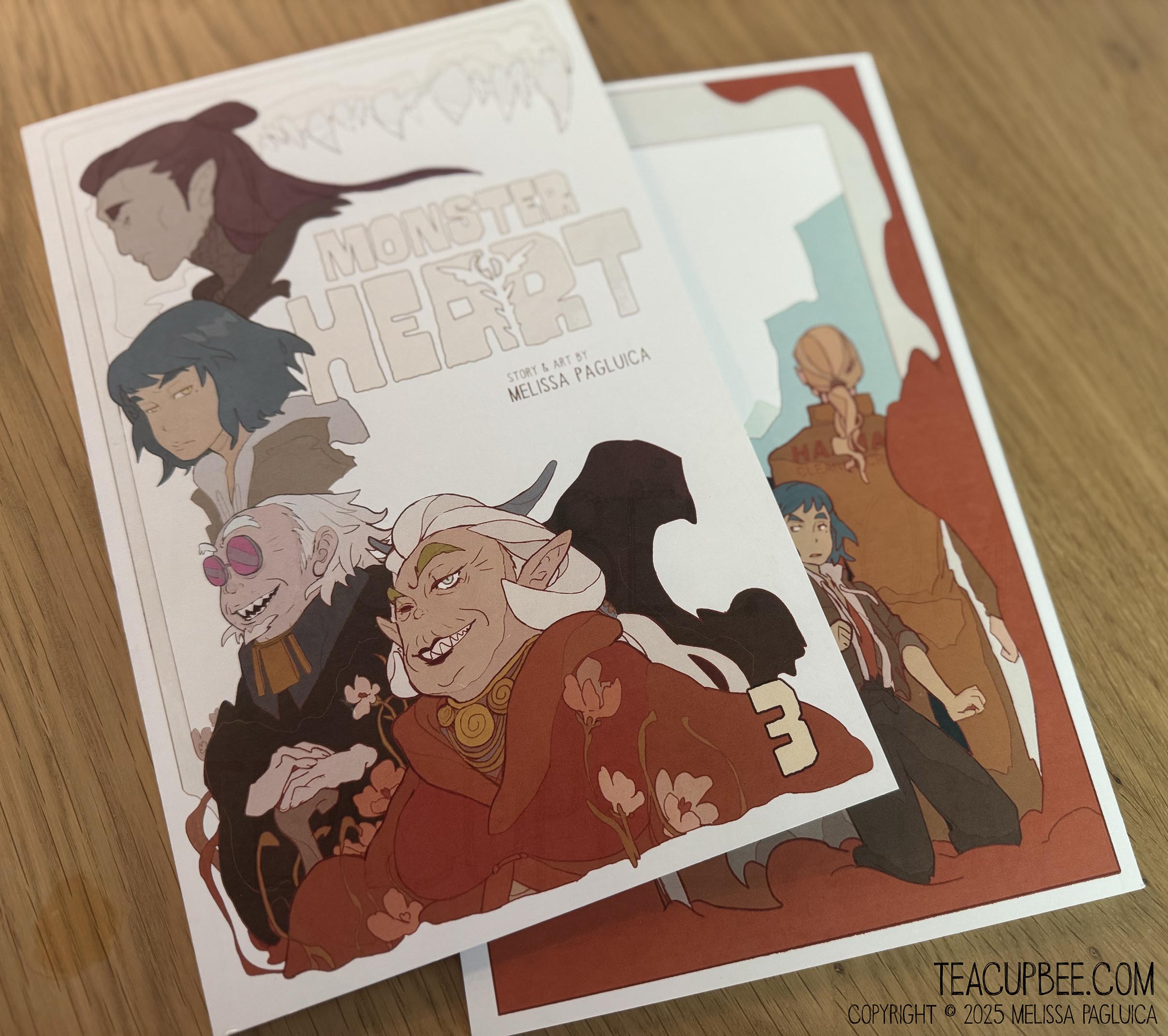 two copies of Monster Heart book 3 sitting on a wooden table.