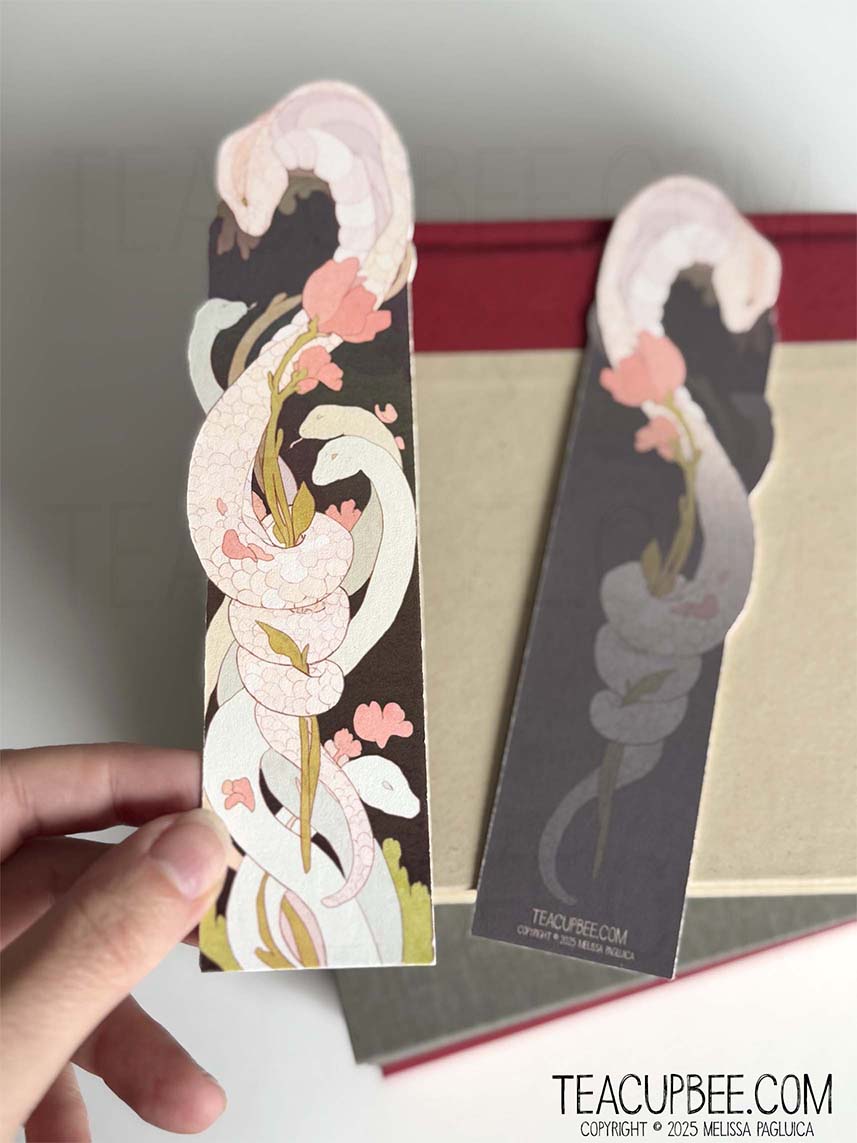 Snake design bookmark held by a hand with a plain background