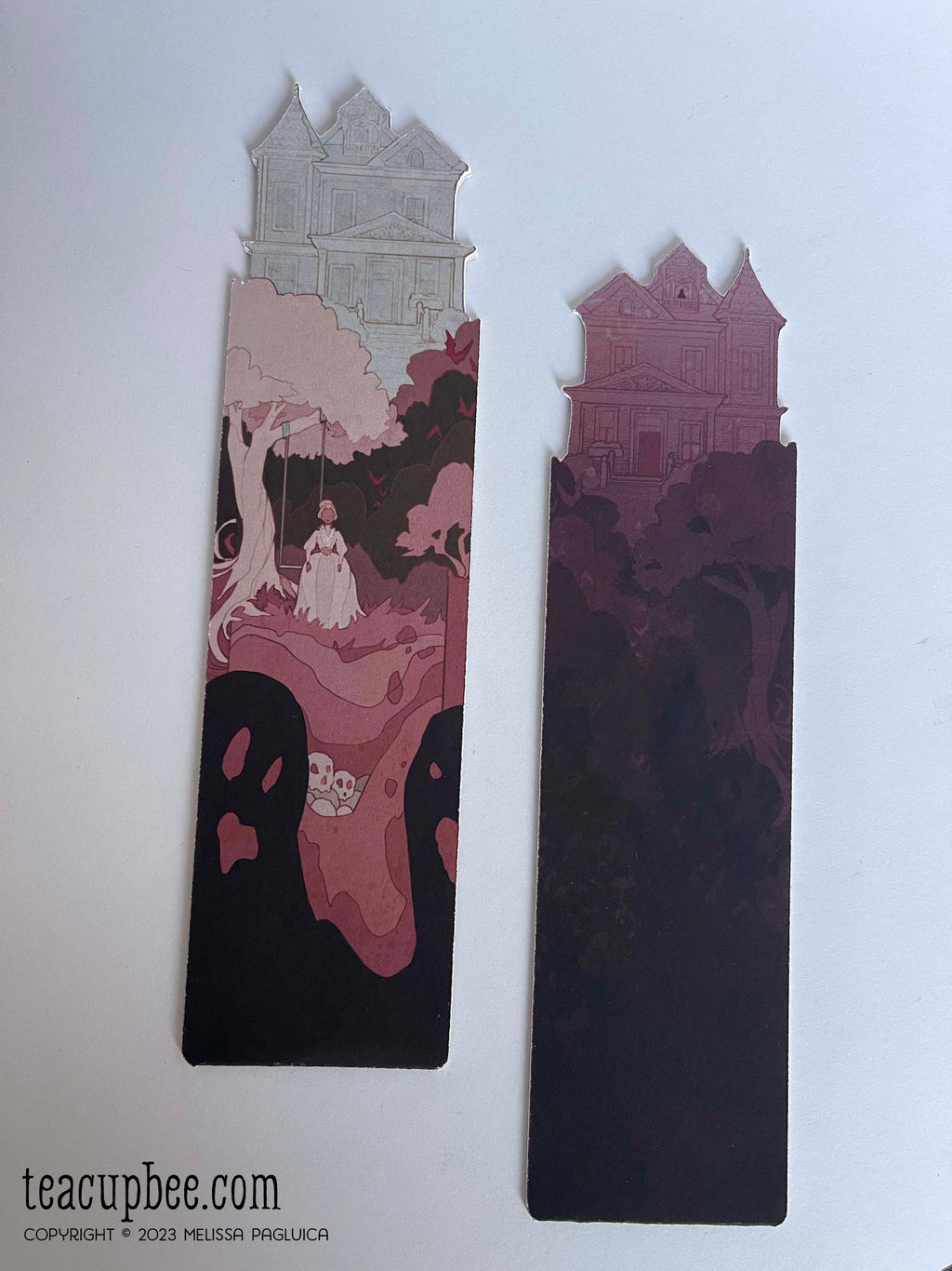 Two artistic bookmarks with architectural haunted house designs on a white background, featuring 'teacupbee.com' branding.